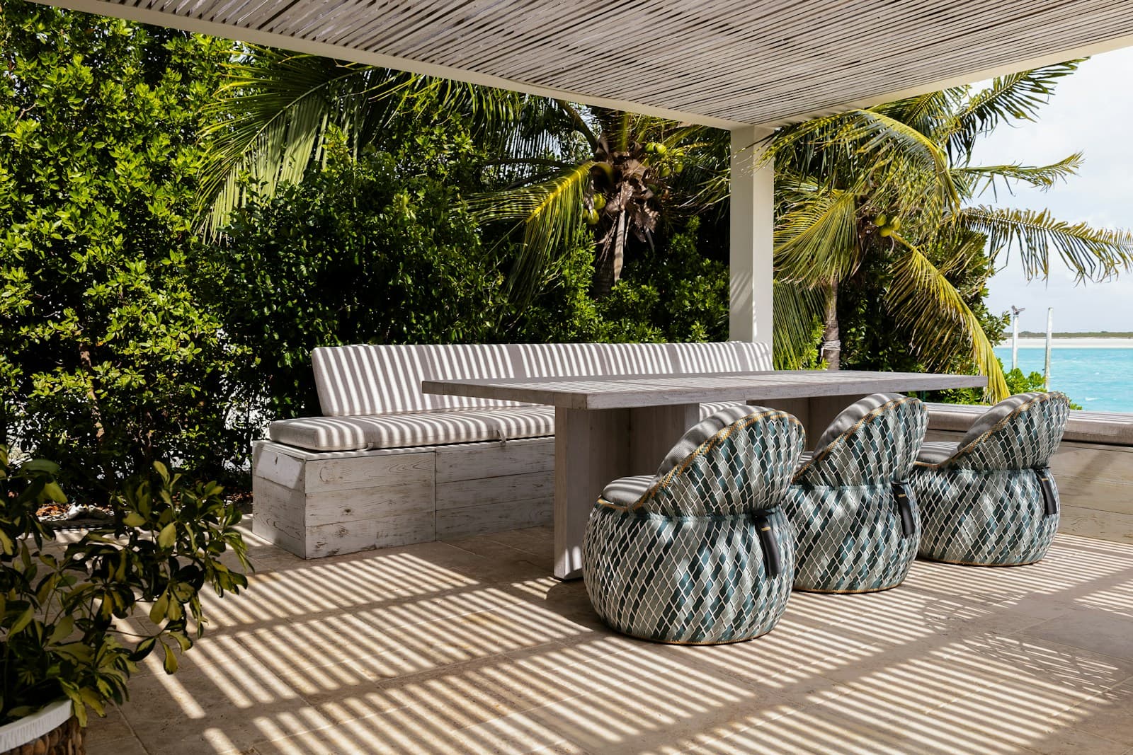 Outdoor dining area under palm trees at a holiday rental